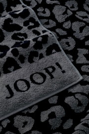 Graues Saunatuch mit schwarzem Leopardenmuster und dem Schriftzug 'JOOP!' in Nahaufnahme.