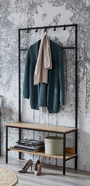 Schwarze Metall-Garderobe mit Holzbank und Ablage, darauf ein grüner Strickcardigan und beiger Schal, Schuhe und Bücher darunter; frontale Perspektive.