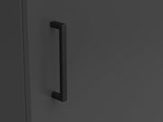 Nahaufnahme eines schwarzen Griffs an einer dunklen Kommode, seitliche Perspektive