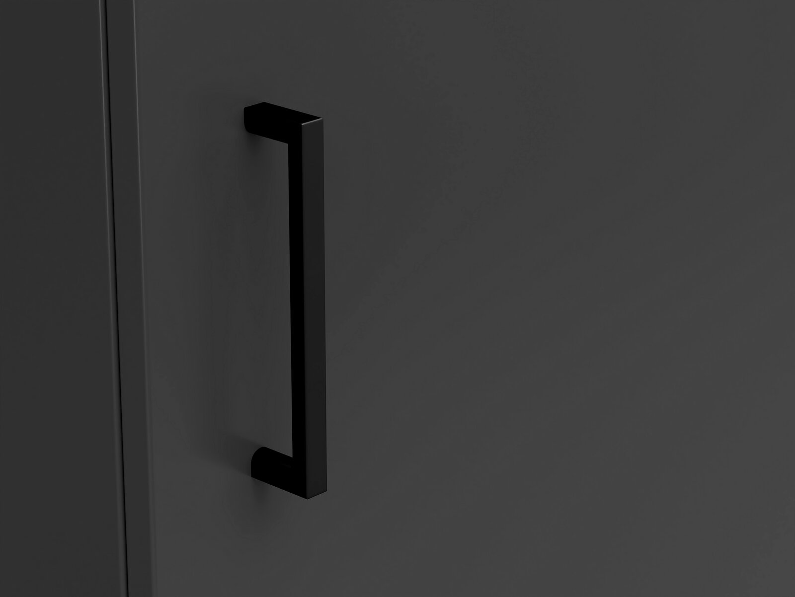 Nahaufnahme eines schwarzen Griffs an einer dunklen Kommode, seitliche Perspektive