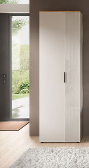 Moderner Garderobenschrank in heller Farbe mit vertikalen Rillen auf einer Tür, seitliche Perspektive.