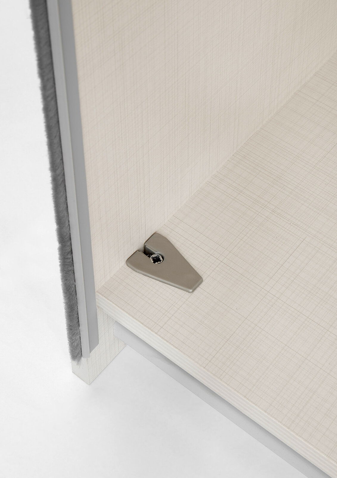 Nahaufnahme einer Ecke eines Schranks mit einem Einlegeboden und einer Befestigungsschraube, aus der Vogelperspektive.