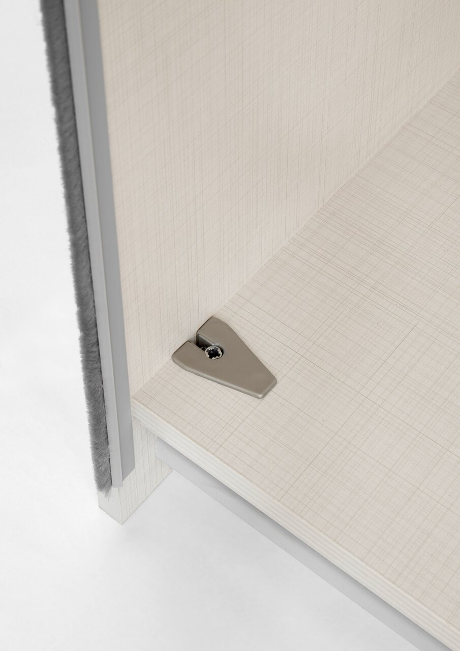 Nahaufnahme einer Ecke eines Schranks mit einem Einlegeboden und einer Befestigungsschraube, aus der Vogelperspektive.