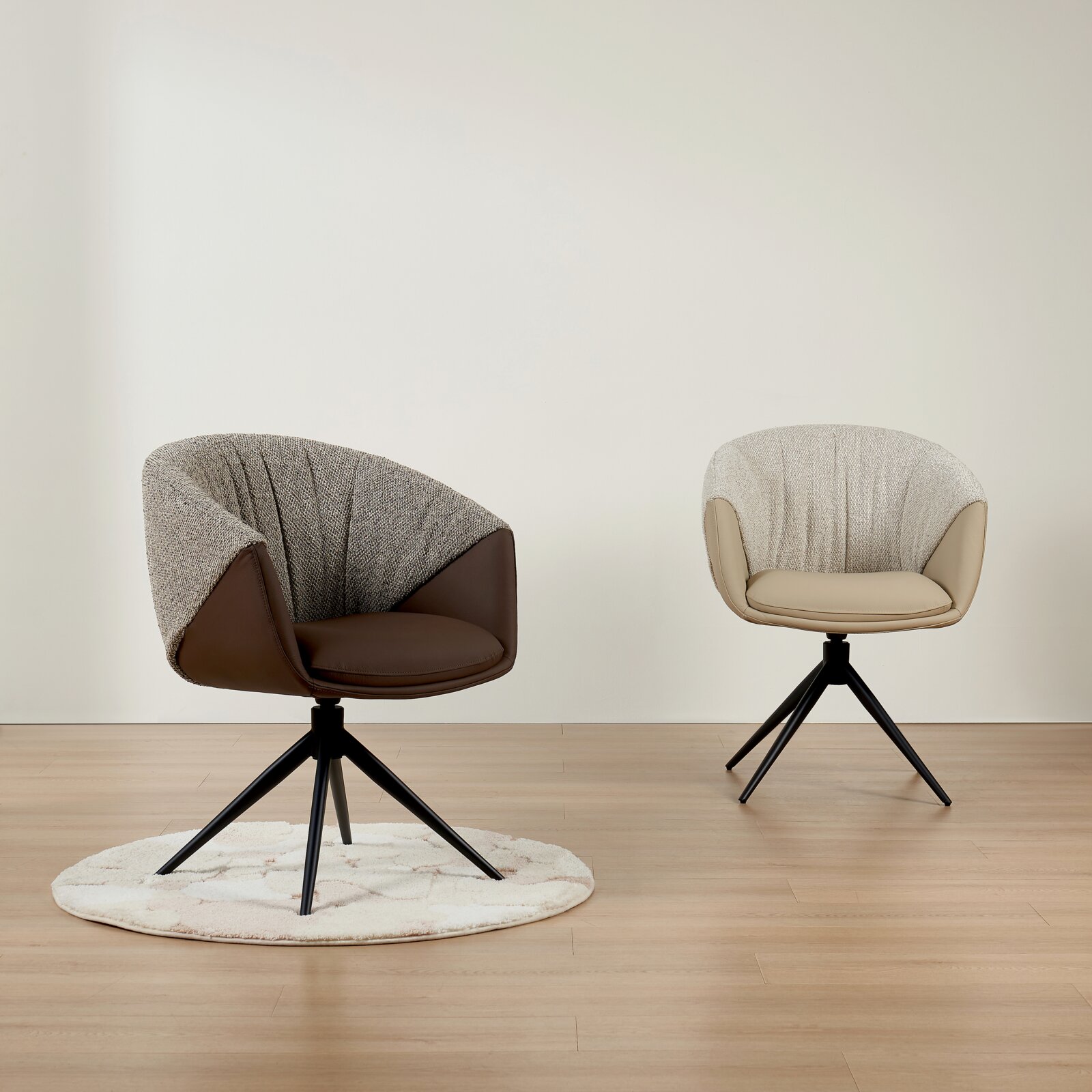 Twee moderne fauteuils met gestoffeerde zittingen en een stoffen bekleding, de ene in bruin en de andere in beige, op een houten vloer. De stoelen zijn te zien vanuit een vooraanzicht.