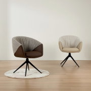Twee moderne fauteuils met gestoffeerde zittingen en een stoffen bekleding, de ene in bruin en de andere in beige, op een houten vloer. De stoelen zijn te zien vanuit een vooraanzicht.