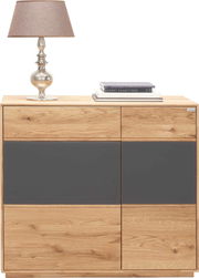 Kommode aus Holz mit grauen Akzenten, darauf eine Tischlampe und Bücher, frontal fotografiert