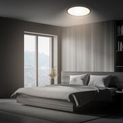 Moderne LED-Deckenleuchte in einem stilvollen Schlafzimmer, von unten betrachtet.