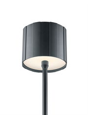 Moderne Akku-Stehleuchte mit schwarzem, geripptem Lampenschirm, Ansicht von unten.