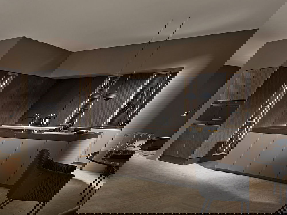 Moderne Küche mit dunklen Schränken, einer Insel mit einem Hocker, einem runden Fenster und einer Mischung aus blauen und hölzernen Akzenten.