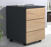 Moderner Rollcontainer mit drei Schubladen, schwarzem Korpus und Holzfronten, in schräger Frontansicht von links auf hellem Teppich; oben liegen Buch, Stift und Brille.