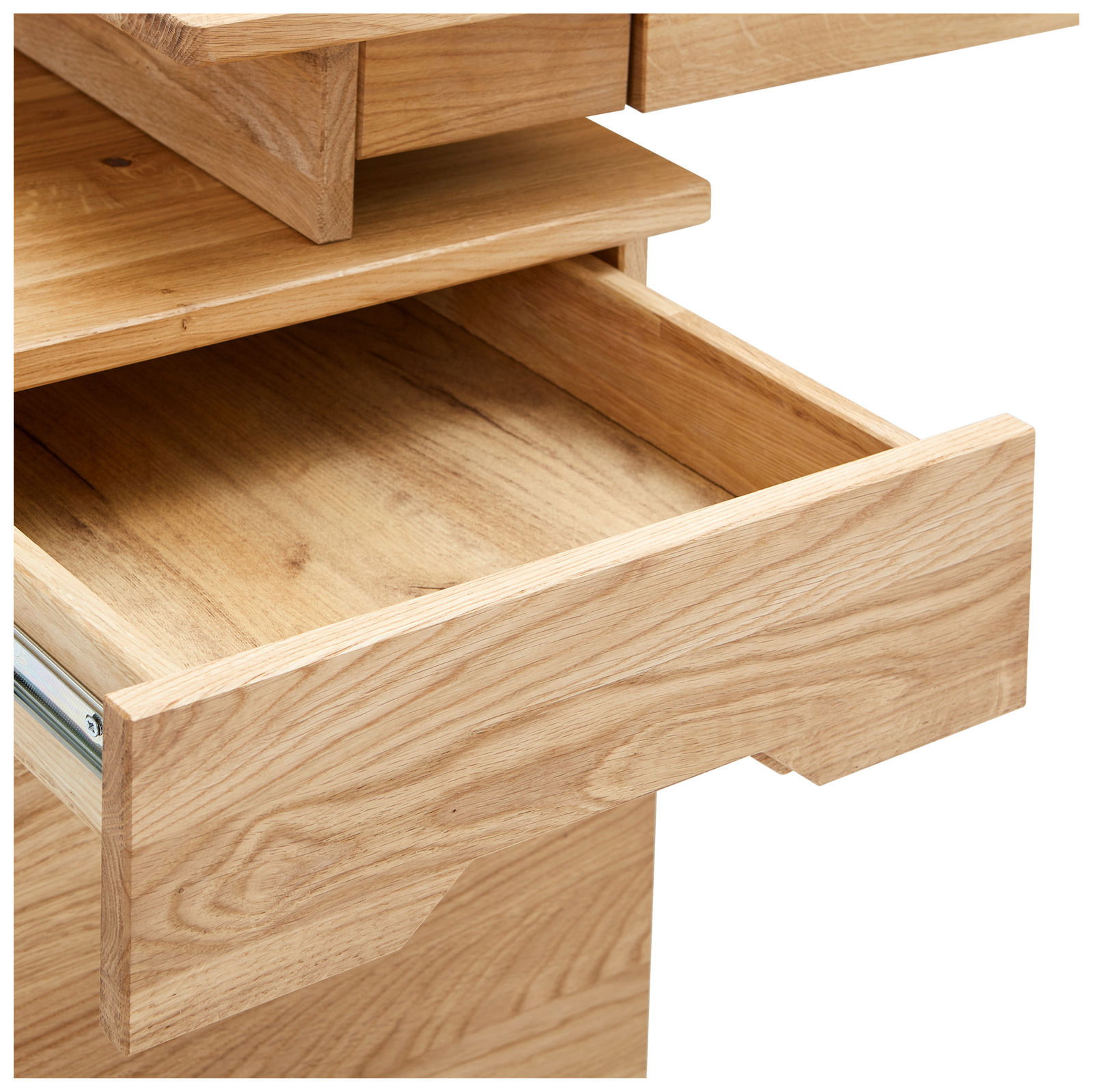 Nahaufnahme eines geöffneten Schreibtischschubfachs aus hellem Holz, von schräg oben fotografiert.