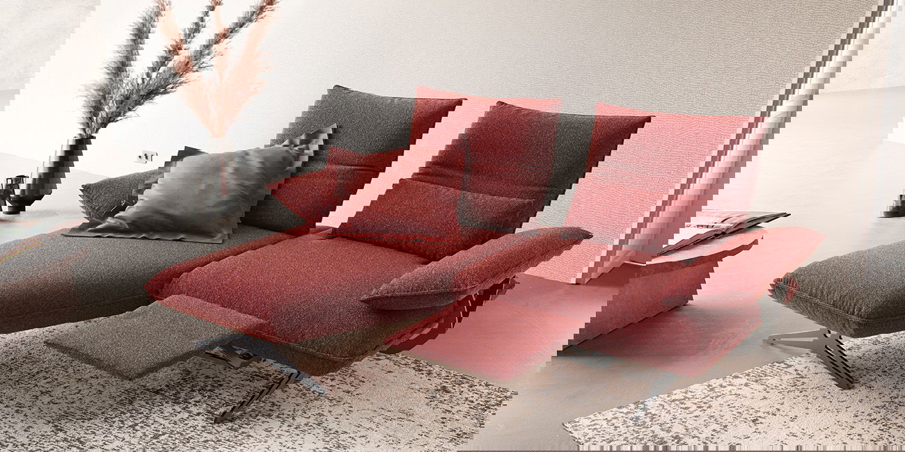  Ein dunkelrotes Sofa mit verstellbaren Sitzflächen.