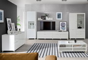 Moderne Wohnzimmermöbel in Weiß, bestehend aus einem TV-Lowboard, Hängeschränken, Vitrinen und einem Couchtisch, aus der Perspektive eines gemütlichen Wohnzimmers.