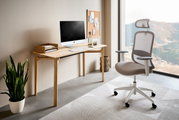 Moderner Drehstuhl mit ergonomischem Design, seitliche Perspektive, in einem hellen Büro neben einem Schreibtisch mit Computer.