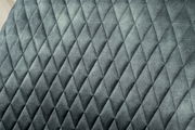 Nahaufnahme der gepolsterten Rückenlehne eines Drehstuhls mit grauem, rautenförmigem Steppmuster.