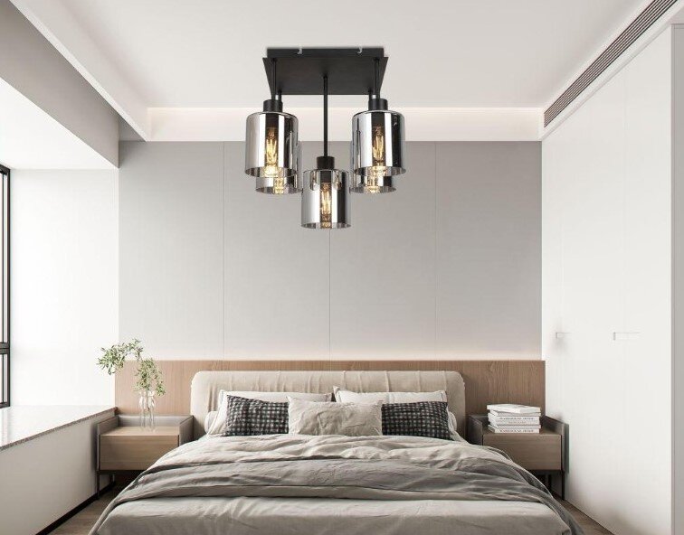 Moderne Deckenleuchte mit mehreren zylindrischen Lampenschirmen in einem stilvollen Schlafzimmer, Perspektive von unten.