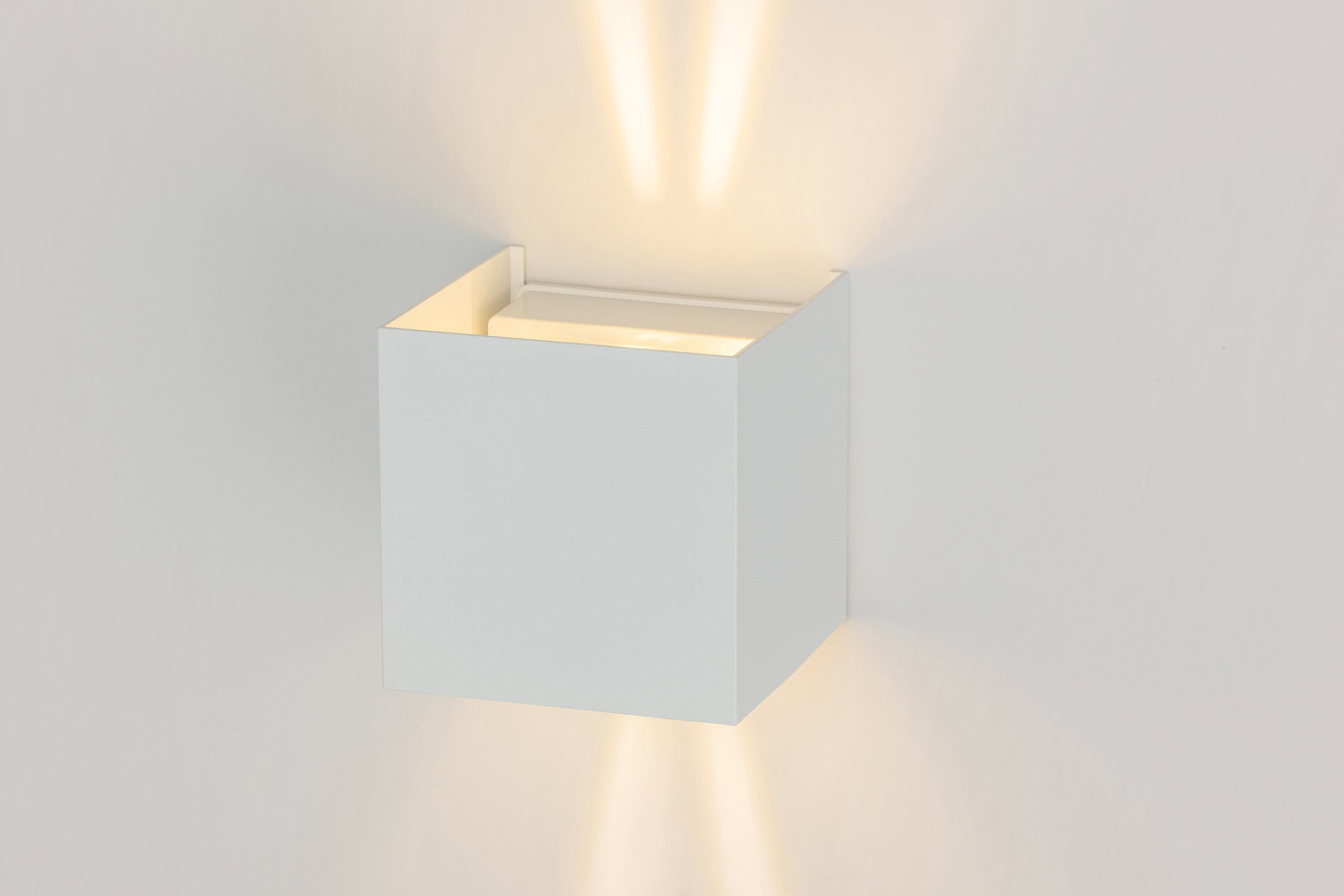 Moderne LED-Wandleuchte in Weiß, die sowohl nach oben als auch nach unten Licht abstrahlt. Perspektive von der Seite.