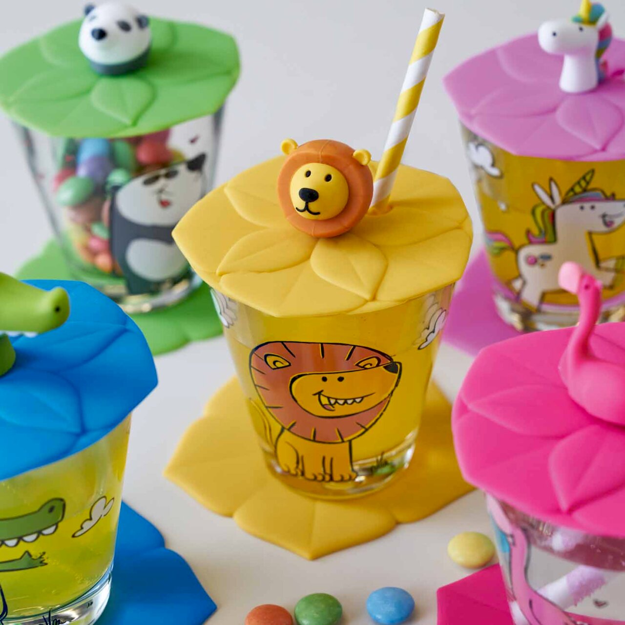 Kindertrinkset mit bunten Tiermotiven, darunter ein Löwe, aus der Vogelperspektive fotografiert.