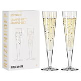 Zwei elegante Champagnergläser mit goldenen und schwarzen Sternmotiven, präsentiert in einer stilvollen Verpackung. Frontalansicht.