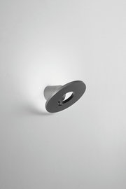 Moderne LED-Außenwandleuchte in seitlicher Perspektive, mit rundem, minimalistischem Design.