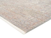 Designer Teppich in sanften Beige- und Grautönen mit subtilen Mustern, perspektivisch von der Seite aufgenommen.