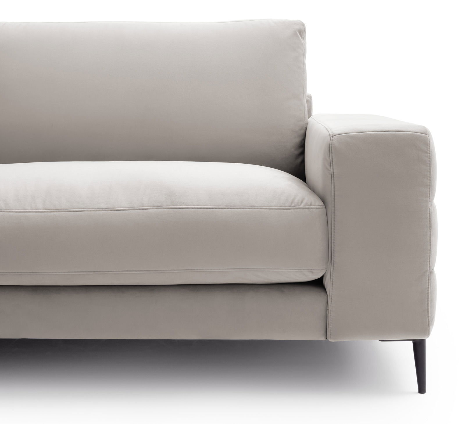 Nahaufnahme eines modernen, beigen Sofas mit Armlehne und schwarzem Bein, seitliche Perspektive