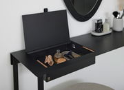 Schwarzer Konsolentisch mit geöffnetem Fach, das verschiedene Accessoires enthält, seitliche Perspektive.