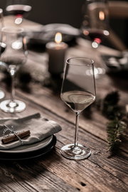 Elegantes Rieslingglas Pure auf einem festlich gedeckten Holztisch, seitliche Perspektive