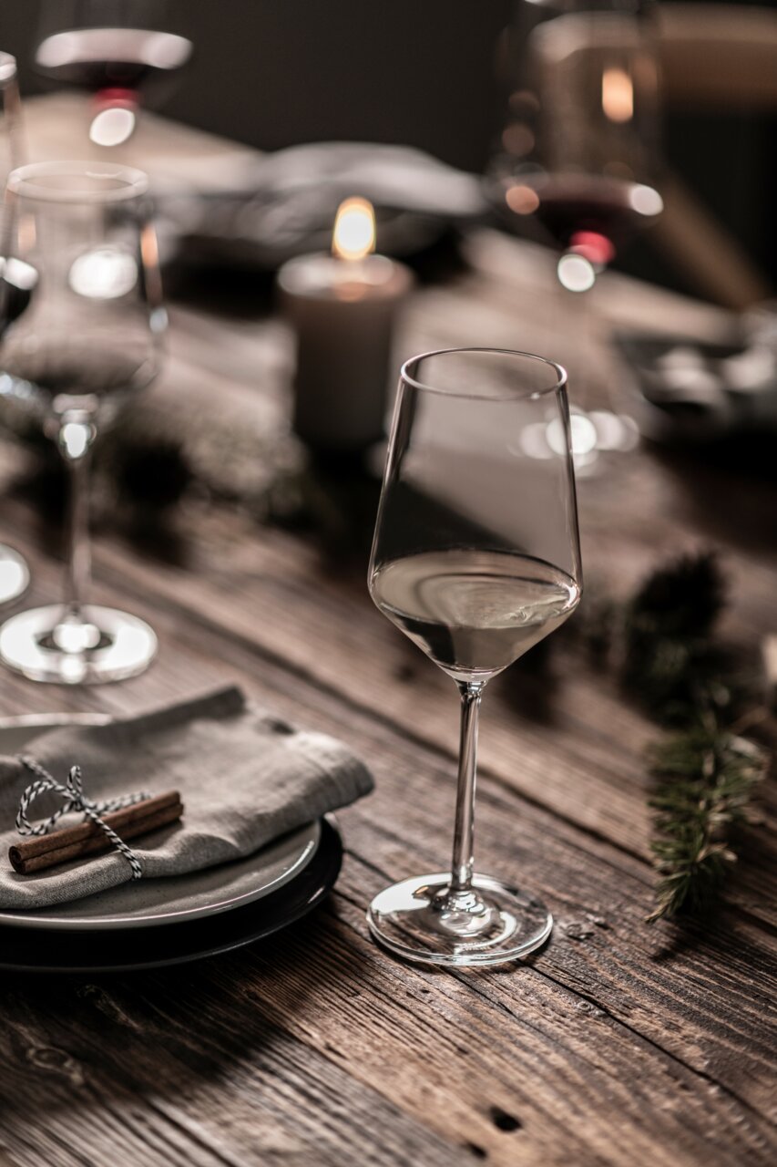 Elegant Rieslingglas Pure op een feestelijk gedekte houten tafel, zijaanzicht