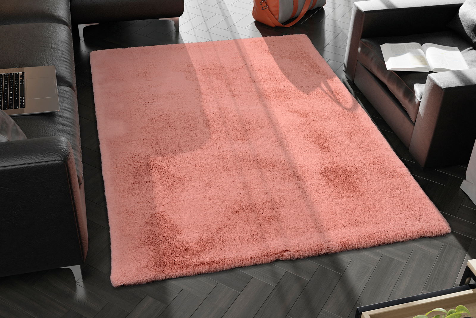 Rosa Fellteppich in einem modernen Wohnzimmer, von oben betrachtet, umgeben von schwarzen Ledersofas und einem Laptop.