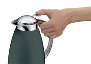 Nahaufnahme aus seitlicher Perspektive: Hand bedient den Verschluss einer dunkelgrünen Isolierkanne mit glänzendem Chromdeckel und Griff.