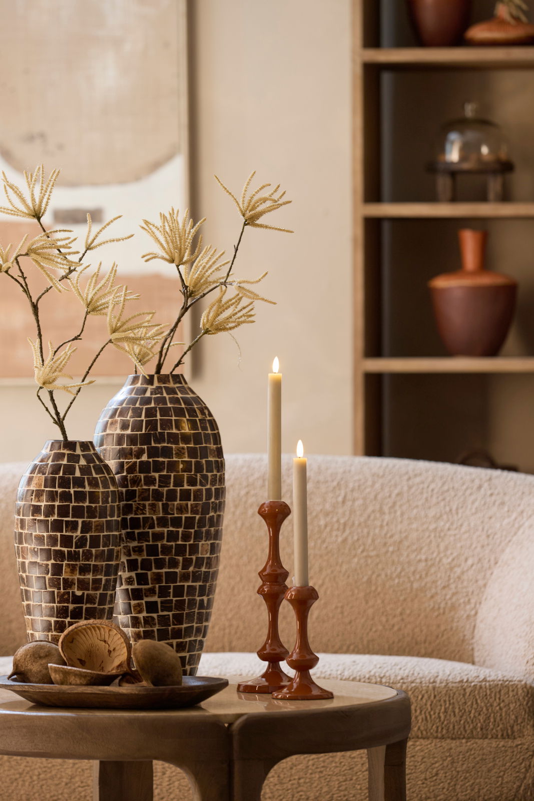 Light&Living Kerzenständer ISARA Zwei elegante Kerzenständer aus Keramik in warmem Braunton mit brennenden Kerzen, auf einem Tisch in einem gemütlichen Wohnzimmer platziert, seitliche Perspektive.