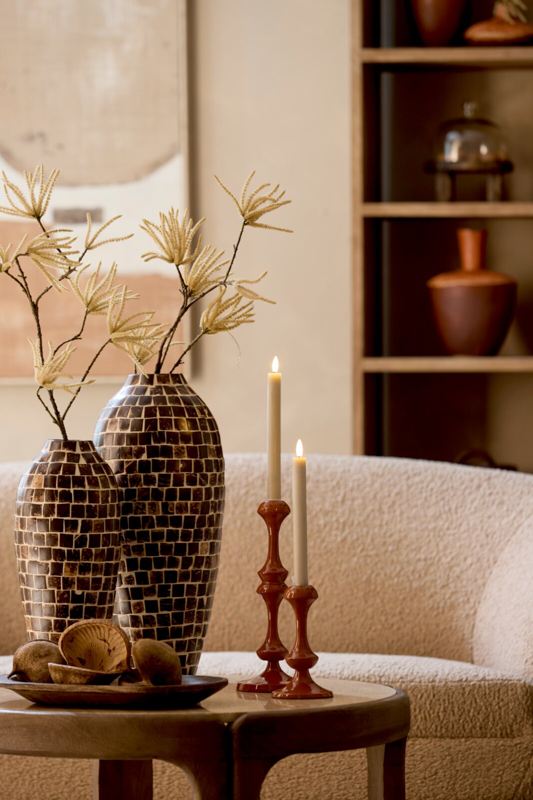 Light&Living Kerzenständer ISARA Zwei elegante Kerzenständer aus Keramik in warmem Braunton mit brennenden Kerzen, auf einem Tisch in einem gemütlichen Wohnzimmer platziert, seitliche Perspektive.