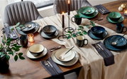 Een elegante servieset van 10-delig op een feestelijk gedekte tafel, met kaarsen en decoratie, gefotografeerd vanuit vogelperspectief.