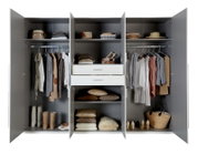 Offener Drehtürenschrank mit sechs Türen, gefüllt mit Kleidung, Schuhen und Accessoires, frontal betrachtet.