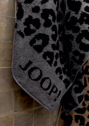 Graues Duschtuch mit schwarzem Leopardenmuster und der Aufschrift 'JOOP!' in Nahaufnahme.