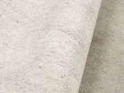 Nahaufnahme eines hellen Wollteppichs mit leicht melierter Textur, von der Seite betrachtet.