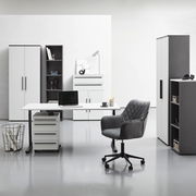 Moderne Büromöbel in einem hellen Raum, bestehend aus einem Winkelschreibtisch mit Rollcontainer, einem Drehstuhl und mehreren Aktenschränken und Regalen, frontal betrachtet.