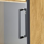 Nahaufnahme eines Vitrinenschranks mit Holzstruktur und modernem, schwarzem Griff, seitliche Perspektive.