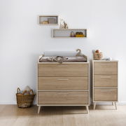 Schmale Kommode aus Holz mit drei Schubladen, neben einer breiteren Kommode mit Wickelauflage, aus der Perspektive von vorne fotografiert.