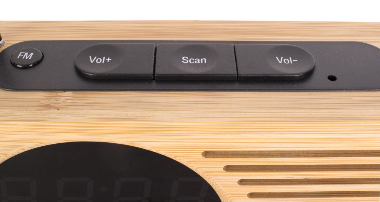 Nahaufnahme eines Radioweckers mit Holzoptik und Bedienelementen für FM, Lautstärke und Scan auf der Oberseite.