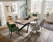 Moderner Esstisch mit Holzplatte und schwarzen Metallbeinen, umgeben von stilvollen Stühlen in einem hellen, eleganten Raum mit großen Fenstern. Perspektive von schräg oben.