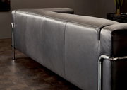 Rückansicht eines modernen grauen 3-Sitzer Sofas mit Metallrahmen in einem stilvollen Raum.