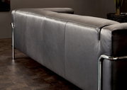 Rückansicht eines modernen grauen 3-Sitzer Sofas mit Metallrahmen in einem stilvollen Raum.