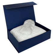 Geschenkset in einer offenen blauen Box mit weichem, weißem Fellinhalt, von oben betrachtet