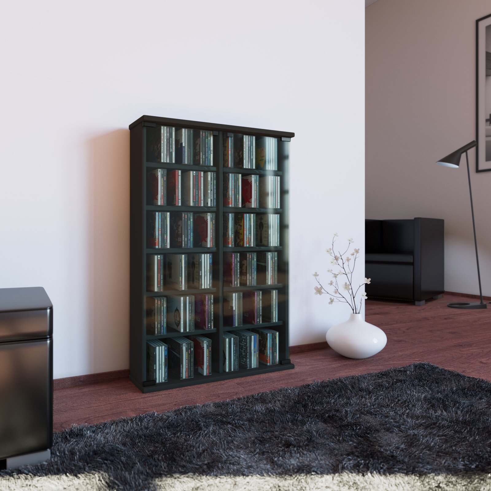 Schwarzes CD-/DVD-Regal mit transparenten Glastüren, gefüllt mit CDs, im Wohnzimmer an der Wand Perspektive: frontale Ansicht leicht von links