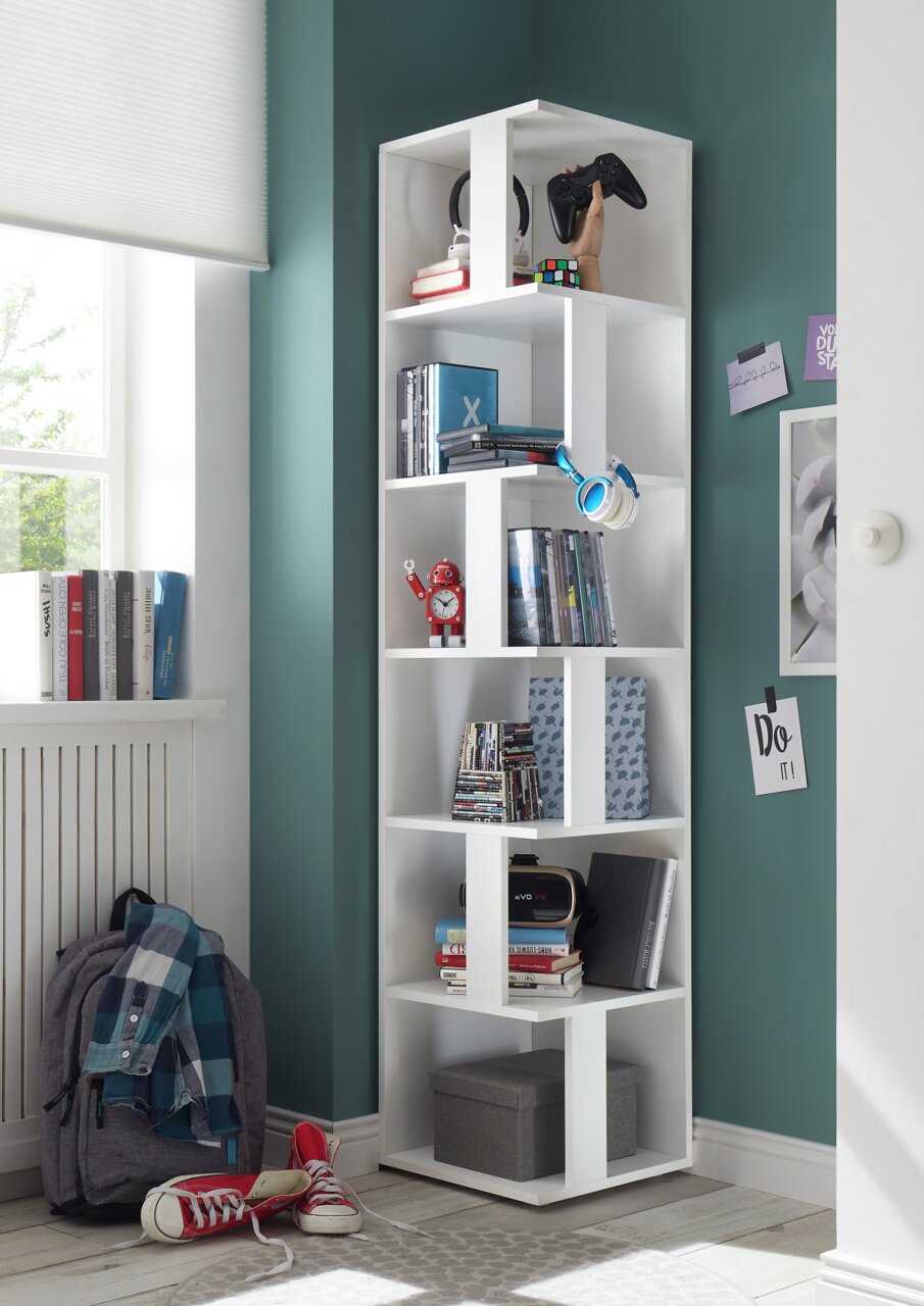 XORA Eckregal ASKIM Weißes Eckregal in einem modernen Raum, gefüllt mit Büchern, Kopfhörern und Dekorationen, aus einer seitlichen Perspektive fotografiert.