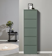 Schmaler, hoher Schuhschrank in mattem Salbeigrün mit fünf Klappfächern, frontal aus leicht erhöhter Perspektive vor heller Wand; oben Deko mit Bild und Schale.