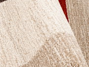 Nahaufnahme eines strukturierten Teppichs in Beige- und Brauntönen mit einem Hauch von Rot, perspektivisch von oben betrachtet.