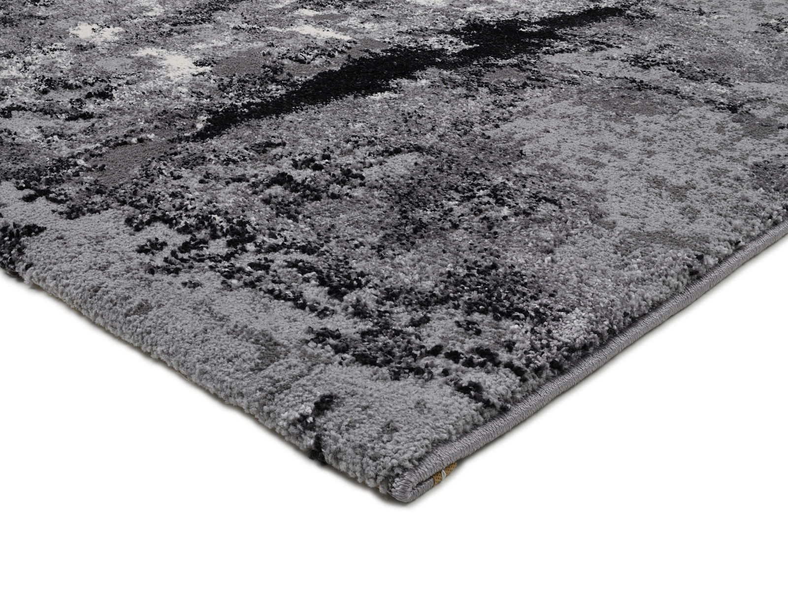 Nahaufnahme eines modernen, grauen Teppichs mit abstraktem Muster, perspektivisch von der Seite aufgenommen.